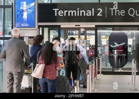 Nachdem sie die Abflughalle am Londoner Heathrow Terminal 2 eingepackt haben, stehen vor dem Terminal Flyer an. Bild aufgenommen am 25.. Juni 2022. © Belinda Jiao Stockfoto