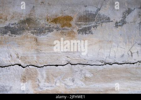 Weiße und graue Zementwand mit tiefem Riss und schwarzem Schimmel und Pilz Stockfoto