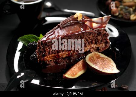 Nahaufnahme Schokoladenkuchen serviert mit Feigen Obst und Kaffee Tasse Stockfoto