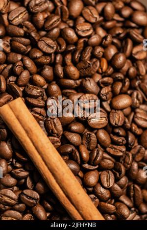 Geröstete Kaffeebohnen und ein Zimt. Hintergrund für Kaffeebohnen Stockfoto