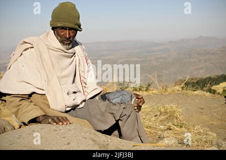 Der alte Mann sitzt auf dem Berg Ashetan, Lalibela, Amhara Region, Äthiopien Stockfoto