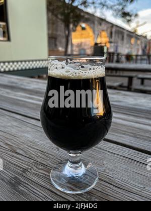 Glasbecher mit Craft-Bier von Cerveceria la Ruina dunkel, braun auf Holztisch in Hermosillo, Mexiko. © (Foto von Luis Gutierrez/Norte Photo) copa de cristal con cerveza artesanal de Cerveceria la Ruina color oscura, color Cafe sobre mesa de madera en Hermosillo, Mexiko. © (Foto von Luis Gutierrez/Norte Photo) Stockfoto