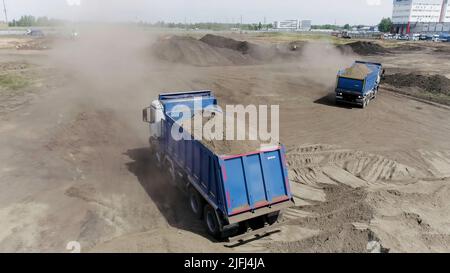 Luftaufnahme des Baggers Schaufel Tonerde zu einem Muldenkipper. Szene. Tätigkeit auf der Baustelle, Schwerindustrie-Konzept. Stockfoto