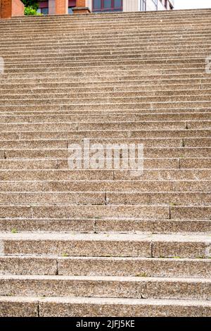 Braune Steintreppe mit abgenutzten Stufen in einem Stadtpark aus der Nähe. Konzeptionelle Sicht auf Karriereentwicklung und Entwicklung Stockfoto