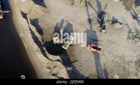 Luftaufnahme von Lastwagen und Maschinen im Sandbruch. Szene. Sandgrube, Ladewagen Sand, Konzept der Schwerindustrie. Stockfoto