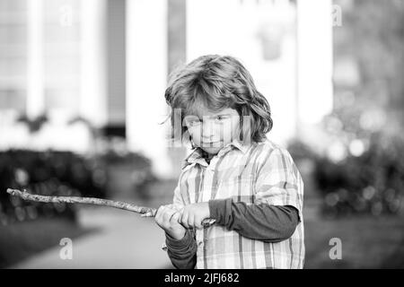 Aggression von Kindern. Negative Emotionen für Kinder. Wütend Junge mit Stock. Anpassung an Kinder. Schläger. Mobbing-Konzept. Nervenzusammenbruch Stockfoto