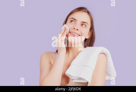 Schöne Frau berührt ihr Gesicht mit Schwamm Wattebausch, Wattebausch. Hautpflege- und Schönheitskonzept. Mädchen entfernt Make-up mit Wattebausch aus dem Gesicht. Stockfoto