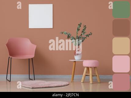 Rosafarbener Stuhl mit Hocker, Tisch und Blumendekor im Innenraum des Zimmers. Unterschiedliche Farbmuster Stockfoto