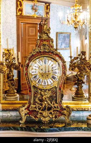 Kunstvolle goldene Uhr, Spiegel und Kamin im Herbst Palace Museum (Muzeum Pałac Herbsta), Lodz, Polen Stockfoto