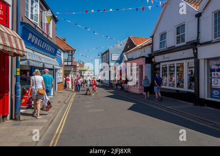 Einkaufsbummel durch die High Street, Sheringham, Norfolk, England. Stockfoto