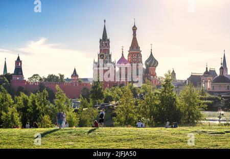 Moskau - 28. Jun 2022: Menschen ruhen im Zaryadye Park in Moskau, Russland. Dieser schöne Park ist Touristenattraktion von Moskau. Panoramablick auf St. Basil Cathedr Stockfoto