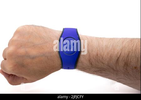 CHESTER, GROSSBRITANNIEN, 03.. JULI 2022: Nahaufnahme eines männlichen Handgelenks mit einem violetten MagicBand Stockfoto