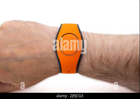 CHESTER, GROSSBRITANNIEN, 03.. JULI 2022: Nahaufnahme eines männlichen Handgelenks mit einem orangefarbenen Disney MagicBand Stockfoto