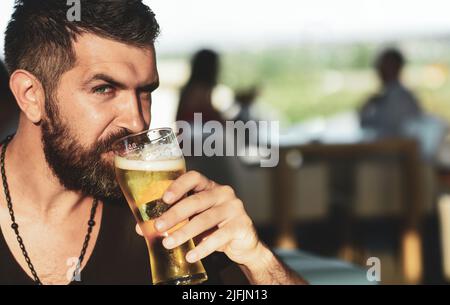 Ein brutaler Hipster-bärtiger Mann sitzt an der Theke. Bierkneipen und Bars Stockfoto