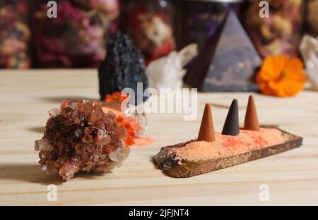 Aragonitkristall mit Weihrauch und Steinpyramide auf Meditationstisch Stockfoto