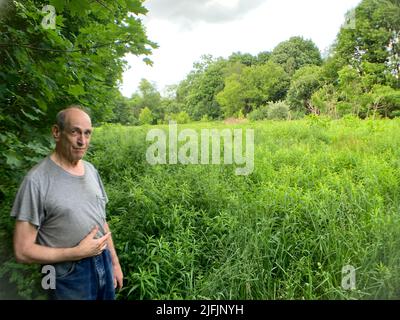 Centralia, USA. 17.. Juni 2022. Harold Mervine steht vor dem mit Unkraut bedeckten ehemaligen Baseballfeld in Centralia. Er war noch nicht einmal ein Teenager, als das tödliche Feuer im Bergbaugebiet Centralia ausbrach. Heute lebt er hier allein in einem Haus, das sein Großvater vor mehr als 100 Jahren gebaut hat. Ein Kohlefeuer hatte die einst blühende Stadt im US-Bundesstaat Pennsylvania in eine Geisterstadt verwandelt. (Um dpa zu berichten: „Geisterstadt über einem Inferno“) Quelle: Benno Schwinghammer/dpa/Alamy Live News Stockfoto