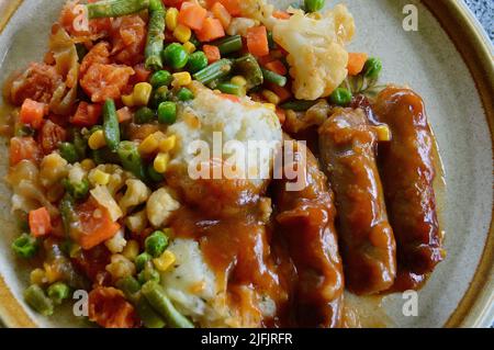 Würstchen mit Zwiebelsoße und Gemüse Stockfoto