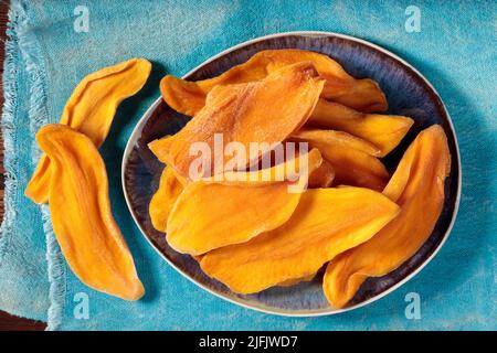Draufsicht auf getrocknete Mangoscheiben auf einem Teller Stockfoto