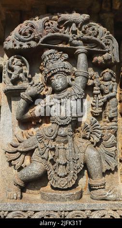 Skulptur von Arjuna, die einen hölzernen Fisch erschießt, indem sie seine Spiegelung in einer Ölschale sieht, Chennakeshava Tempel, Aralguppe, Tumkur, Karnataka, Indien. Stockfoto