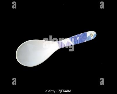 Großer Plastiklöffel isoliert auf schwarzem Hintergrund Stockfoto