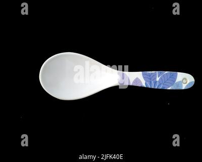 Großer Plastiklöffel isoliert auf schwarzem Hintergrund Stockfoto