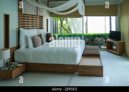 Helles und gemütliches, modernes asiatisches Schlafzimmer mit Doppelbett Stockfoto