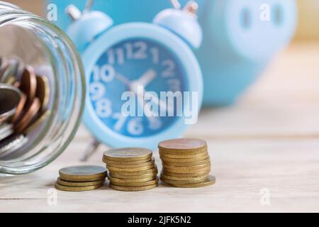 Münzstapel auf Holztisch Hintergrund. Schreibtisch mit Geldmünzen und Geschäftsplanung. Sparkonzept Stockfoto