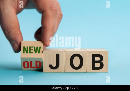 Alter Job und neuer Job, Karriere verändern das konzeptuelle Image. Hand dreht Holzwürfel und ändert den Ausdruck alter Job in neuen Job. Stockfoto