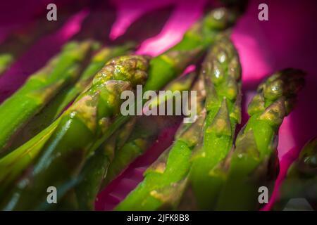 Gefrorener Spargel kommt in Wasser vor Stockfoto