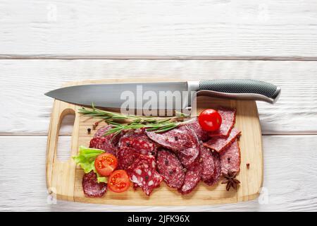 Salami und Messer auf Schneidebrett Freiraum Stockfoto