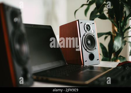 Workstation mit Lautsprechern und Computer im Studio. Desktop im Heimbüro. Selektiver Fokus auf den Sprecher. Stockfoto