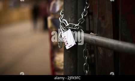 Vorhängeschloss an einer Kette. Verschlossen und verschlossen. Geheimnisvoll und sicher. Detailfoto Stockfoto