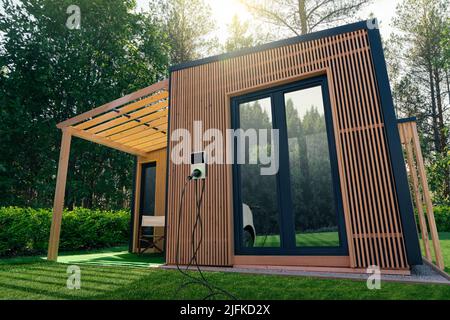 Holzhaus im Wald mit einer Ladestation für Elektroautos an der Wand. Konzept Stockfoto