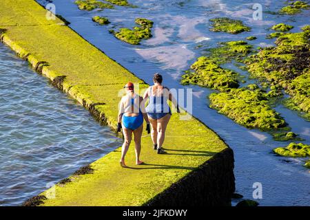 Foto-Shows: Schönes Wochenend-Wetter in Margate, als Badegäste den Walpole Bay Gezeitenpool nutzten. Schleichend entlang der rutschigen Moos beladen Themse Es Stockfoto