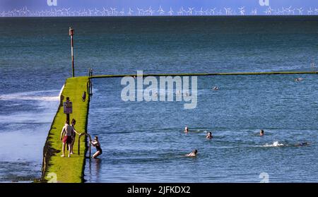 Foto-Shows: Schönes Wochenend-Wetter in Margate, als Badegäste den Walpole Bay Gezeitenpool nutzten. Schleichend entlang der rutschigen Moos beladen Themse Es Stockfoto