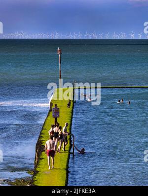 Foto-Shows: Schönes Wochenend-Wetter in Margate, als Badegäste den Walpole Bay Gezeitenpool nutzten. Schleichend entlang der rutschigen Moos beladen Themse Es Stockfoto