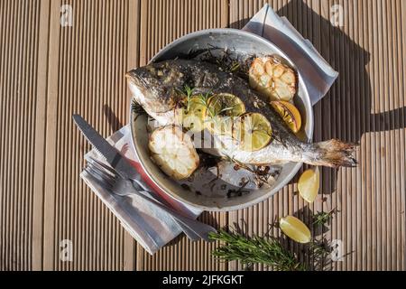 Köstlicher gegrillter dorado-Fisch mit Zitrone und Petersilie. Ganze BBQ-Seebrasse gebacken. Dorado Grill. Ketogen, Keto oder Paläo-Diät Mittagessen, gesunde Ernährung Trend Stockfoto