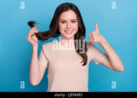 Foto von jungen attraktiven Dame zeigt Daumen-up empfehlen Shampoo Marke isoliert auf blauem Hintergrund Stockfoto