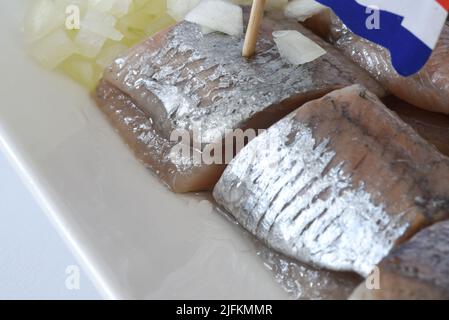 Den Helder, Niederlande. Juni 2022. Nahaufnahme von rohem Hering mit holländischer Flagge und Zwiebeln. Hochwertige Fotos. Nahaufnahme. Selektiver Fokus. Stockfoto