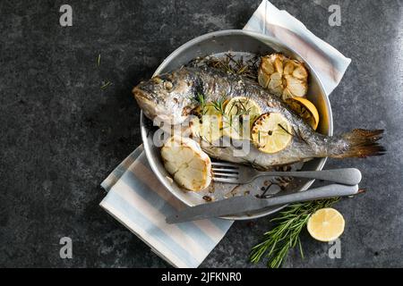 Köstlicher gegrillter dorado-Fisch mit Zitrone und Petersilie. Ganze BBQ-Seebrasse gebacken. Dorado Grill. Ketogen, Keto oder Paläo-Diät Mittagessen, gesunde Ernährung Trend Stockfoto