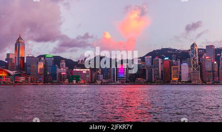 Hong Kong - 13. Juli 2017: Hong Kong Central District am Abend stehen beleuchtete Wolkenkratzer an der Küste, im modernen asiatischen Stadtbild Stockfoto