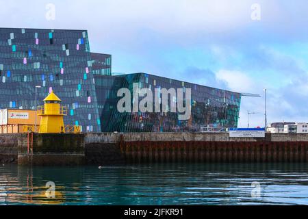 Reykjavik, Island - 4. April 2017: Gelber Leuchtturm-Turm vor der Harpa-Konzerthalle und dem Konferenzzentrum Stockfoto