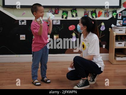 Peking, China. 4.. Juli 2022. Ein Kind interagiert mit seiner Lehrerin, während ein Kindergarten in Peking, der Hauptstadt Chinas, wieder eröffnet wird, 4. Juli 2022. Kindergärten in Beijng wiedereröffnet am Montag. Quelle: Ren Chao/Xinhua/Alamy Live News Stockfoto