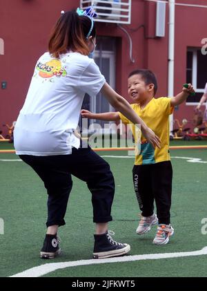 Peking, China. 4.. Juli 2022. Ein Kind umarmt seine Lehrerin, als ein Kindergarten in Peking, der Hauptstadt Chinas, wieder eröffnet wird, 4. Juli 2022. Kindergärten in Beijng wiedereröffnet am Montag. Quelle: Ren Chao/Xinhua/Alamy Live News Stockfoto