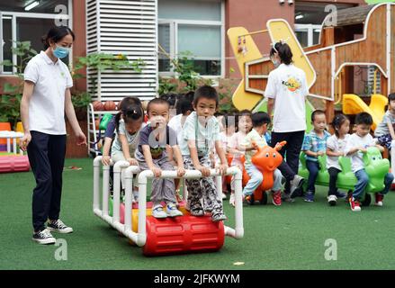 Peking, China. 4.. Juli 2022. Kinder spielen draußen, während ein Kindergarten in Peking, der Hauptstadt Chinas, wieder eröffnet wird, 4. Juli 2022. Kindergärten in Beijng wiedereröffnet am Montag. Quelle: Ren Chao/Xinhua/Alamy Live News Stockfoto