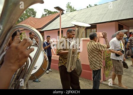 Dorfbewohner spielen Trompete und Saxophon während einer ländlichen Orchesteraufführung, um Touristen im Dorf Rumahkay, Amalatu, West Seram, Maluku, Indonesien willkommen zu heißen. Stockfoto