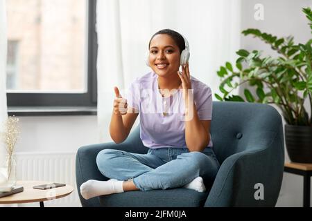 Frau mit Kopfhörern, die zu Hause Musik hört Stockfoto
