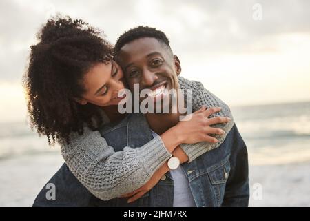 Lächelndes junges multiethnisches Paar, das einen lustigen Nachmittag am Strand hat Stockfoto