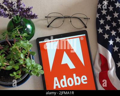 In dieser Abbildung sehen Sie das Logo von Adobe, Inc., das auf einem Tablet angezeigt wird Stockfoto