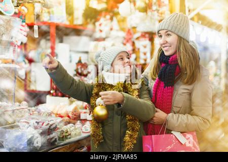 Mädchen mit Frau Wahl Weihnachtsgeschenke für die Familie Stockfoto